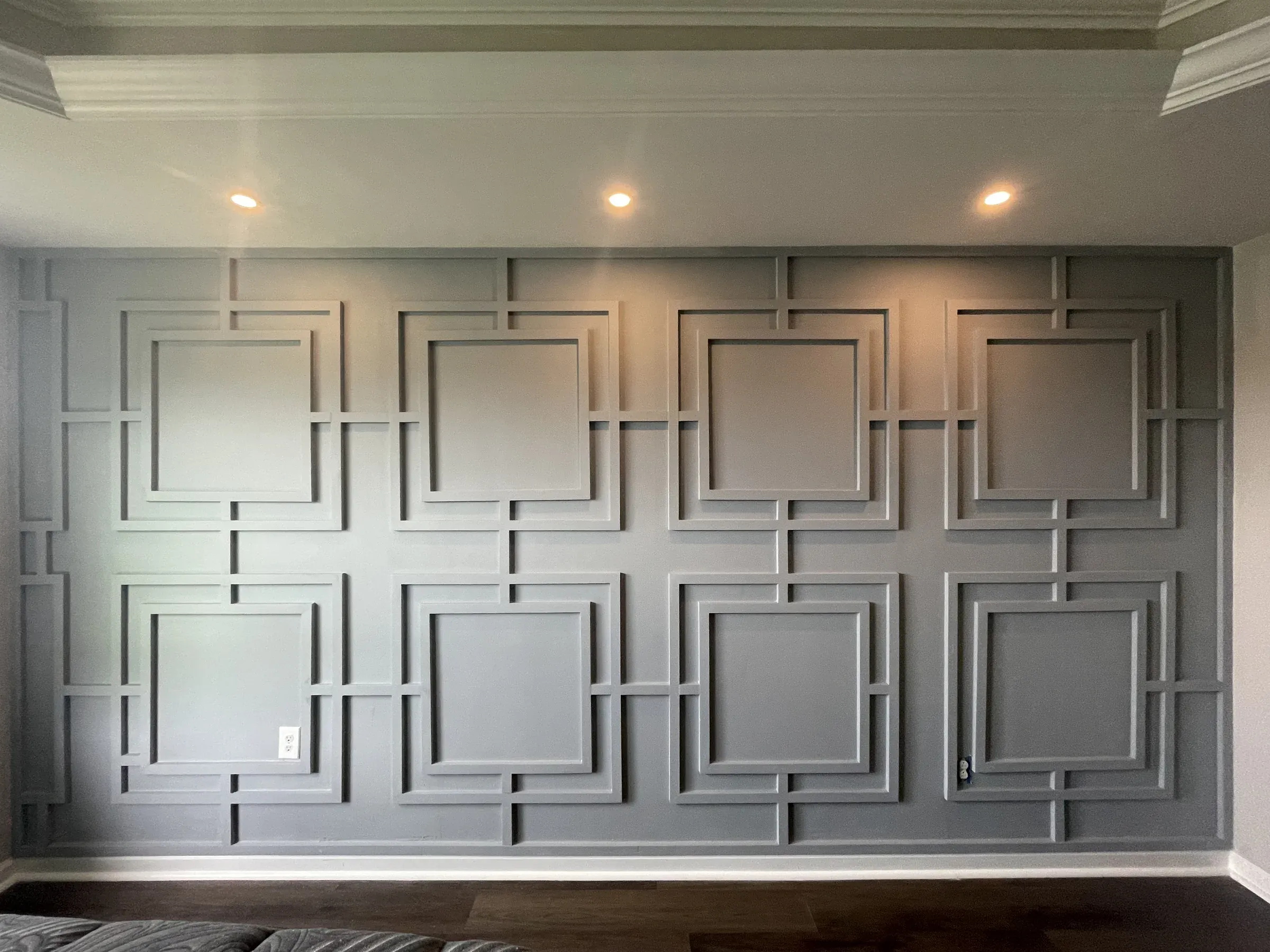 Custom geometric wainscoting accent wall with painted square trim panels, coffered detail and crown molding — Zavala & Sons finish carpentry