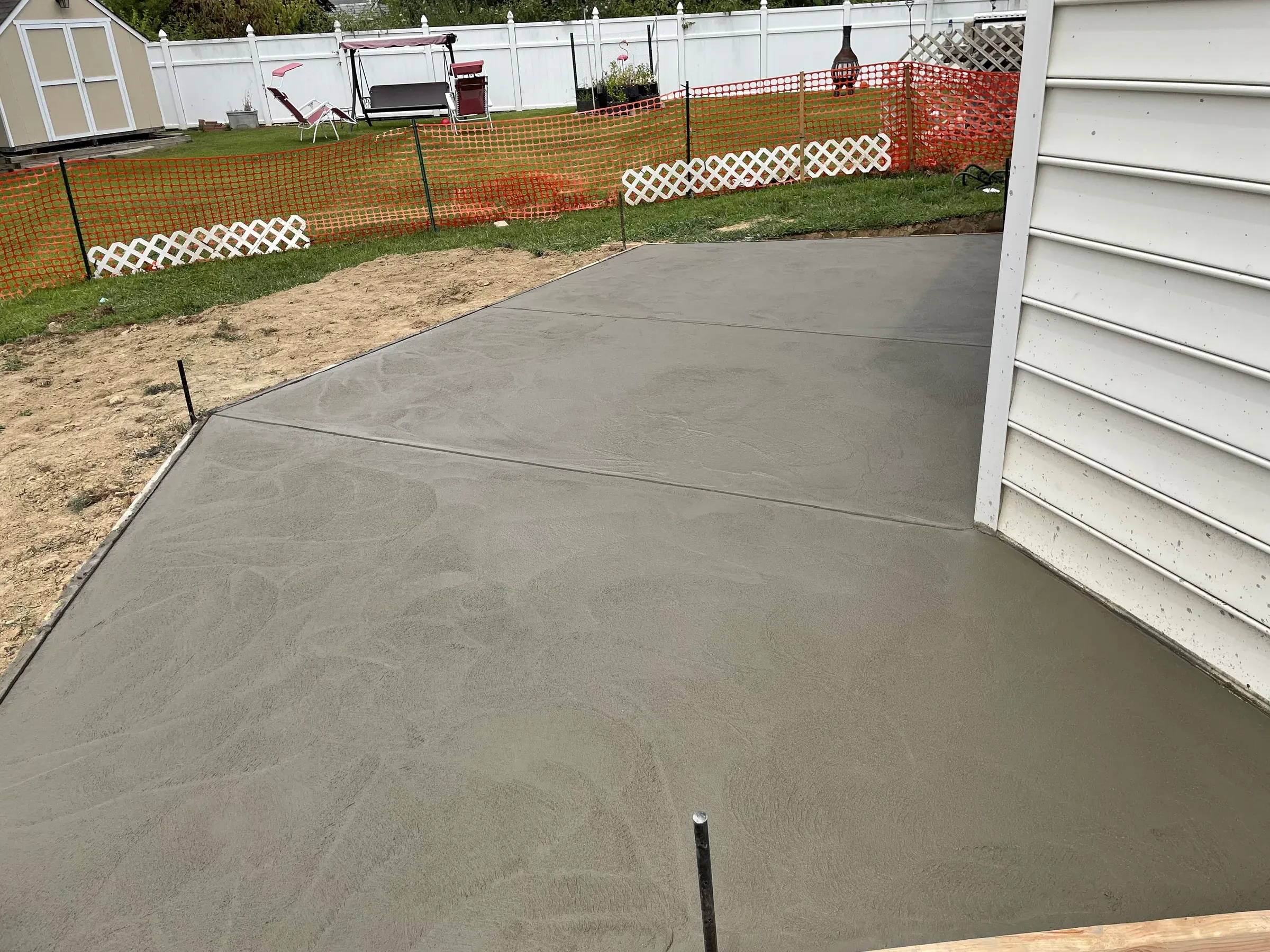 Freshly poured backyard concrete patio with smooth broom finish, residential concrete flatwork by Zavala & Sons in Delaware