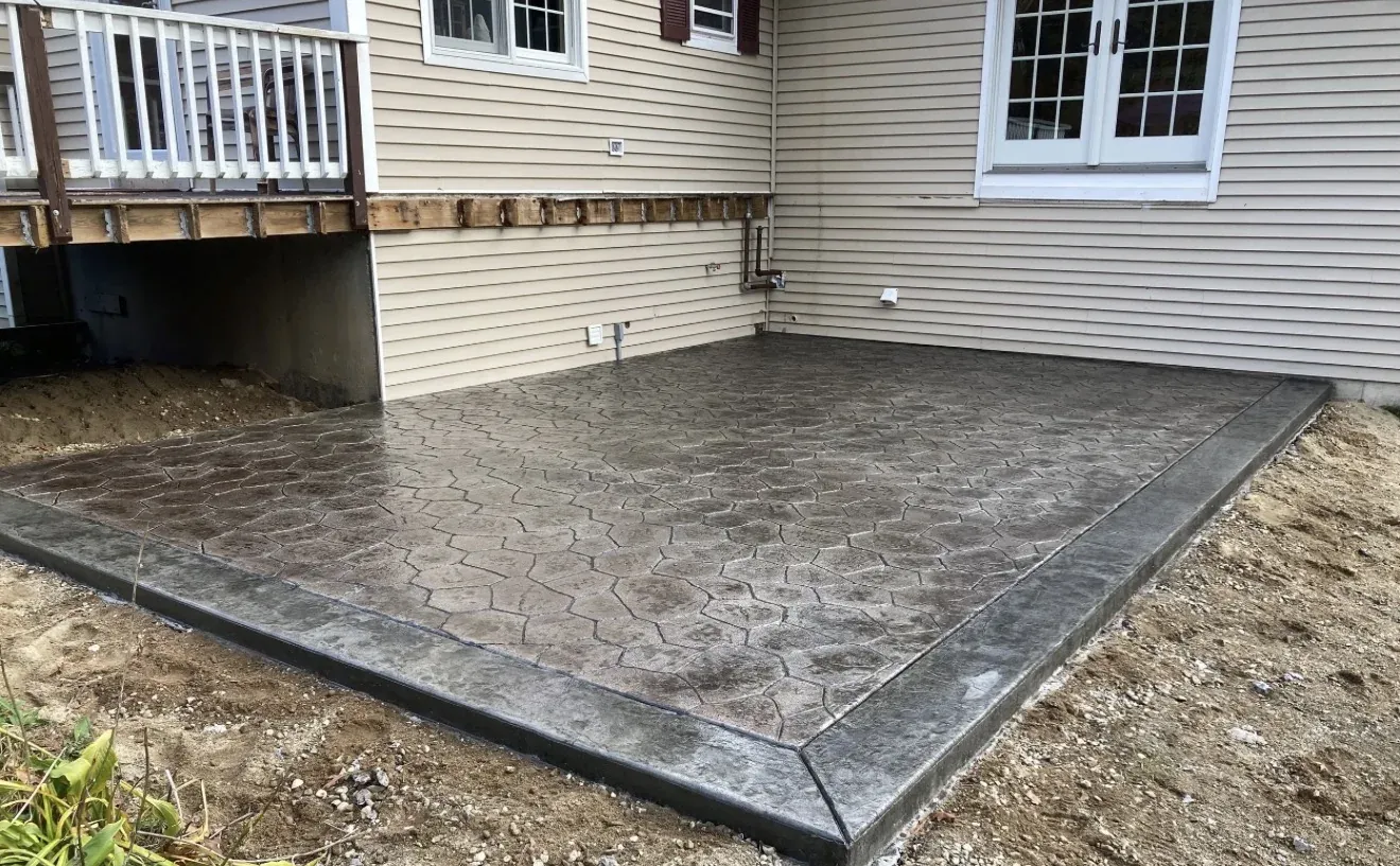 Stamped decorative concrete patio with cobblestone pattern and tooled border off rear deck — Wilmington DE outdoor living