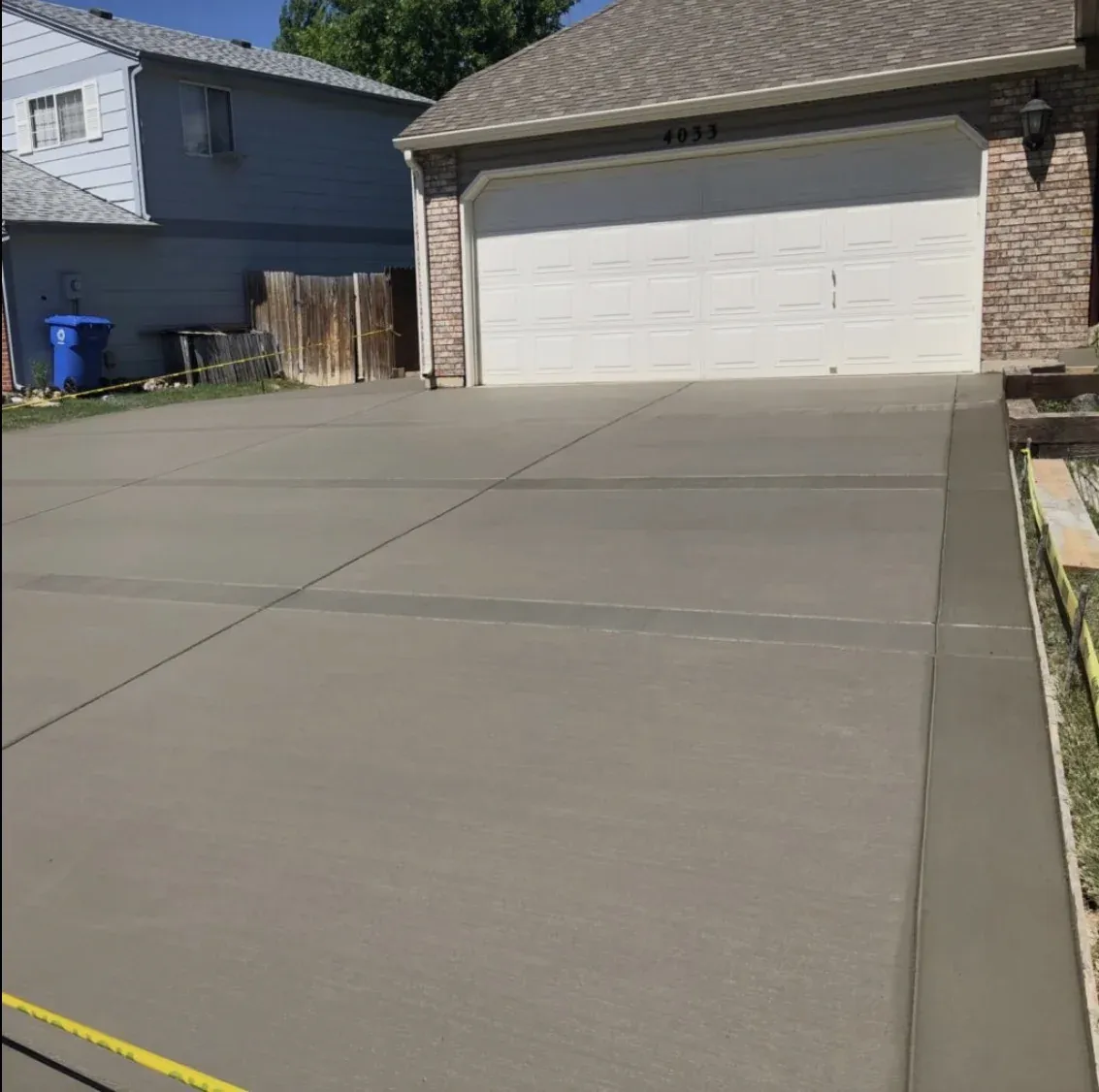 Two-car concrete driveway with broom-finish texture and saw-cut control joints, Zavala & Sons residential concrete installation