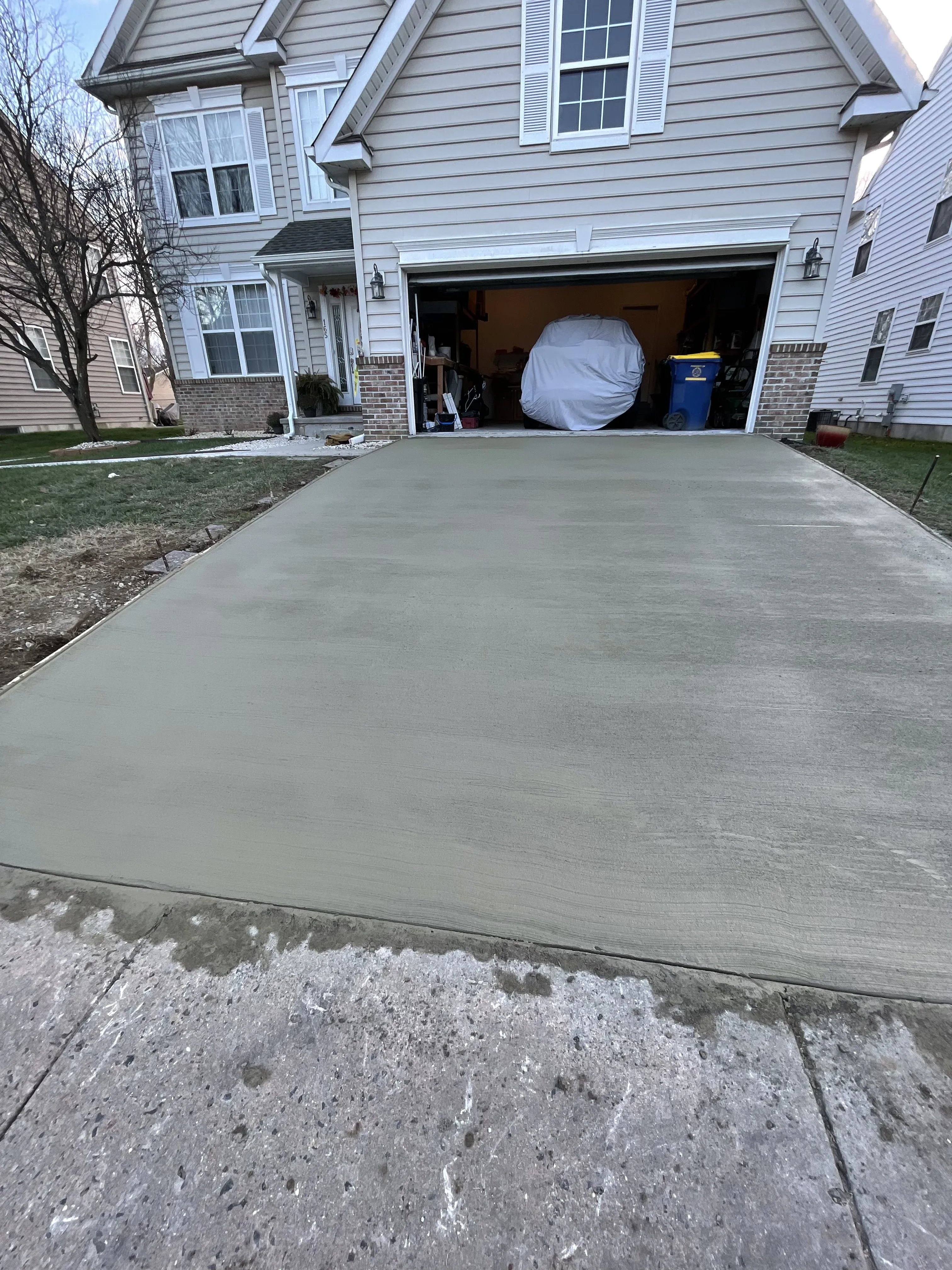 Smooth-finish concrete driveway poured in front of two-story home in Delaware by Zavala & Sons concrete crew