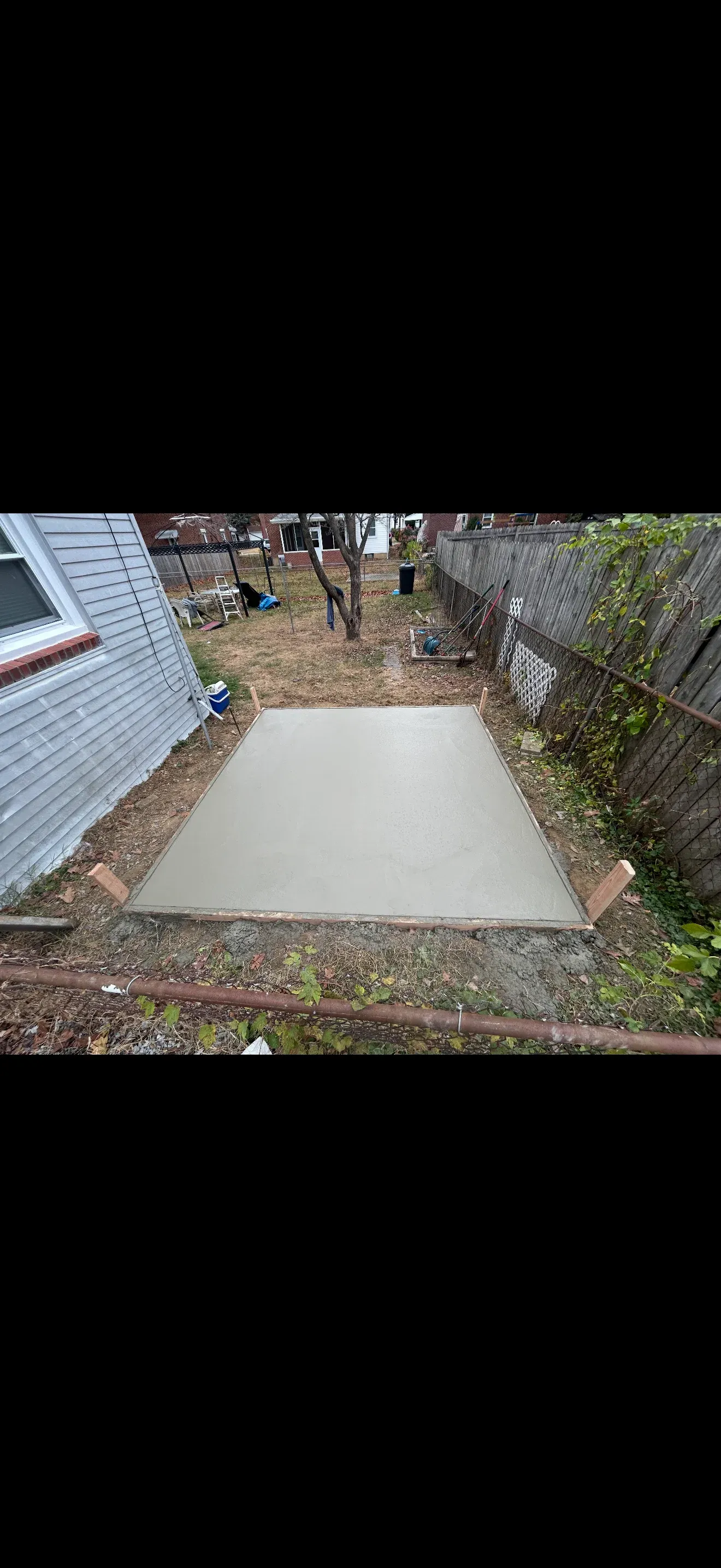 Small concrete pad poured in side yard between homes with wood forms — Zavala & Sons concrete service in Delaware