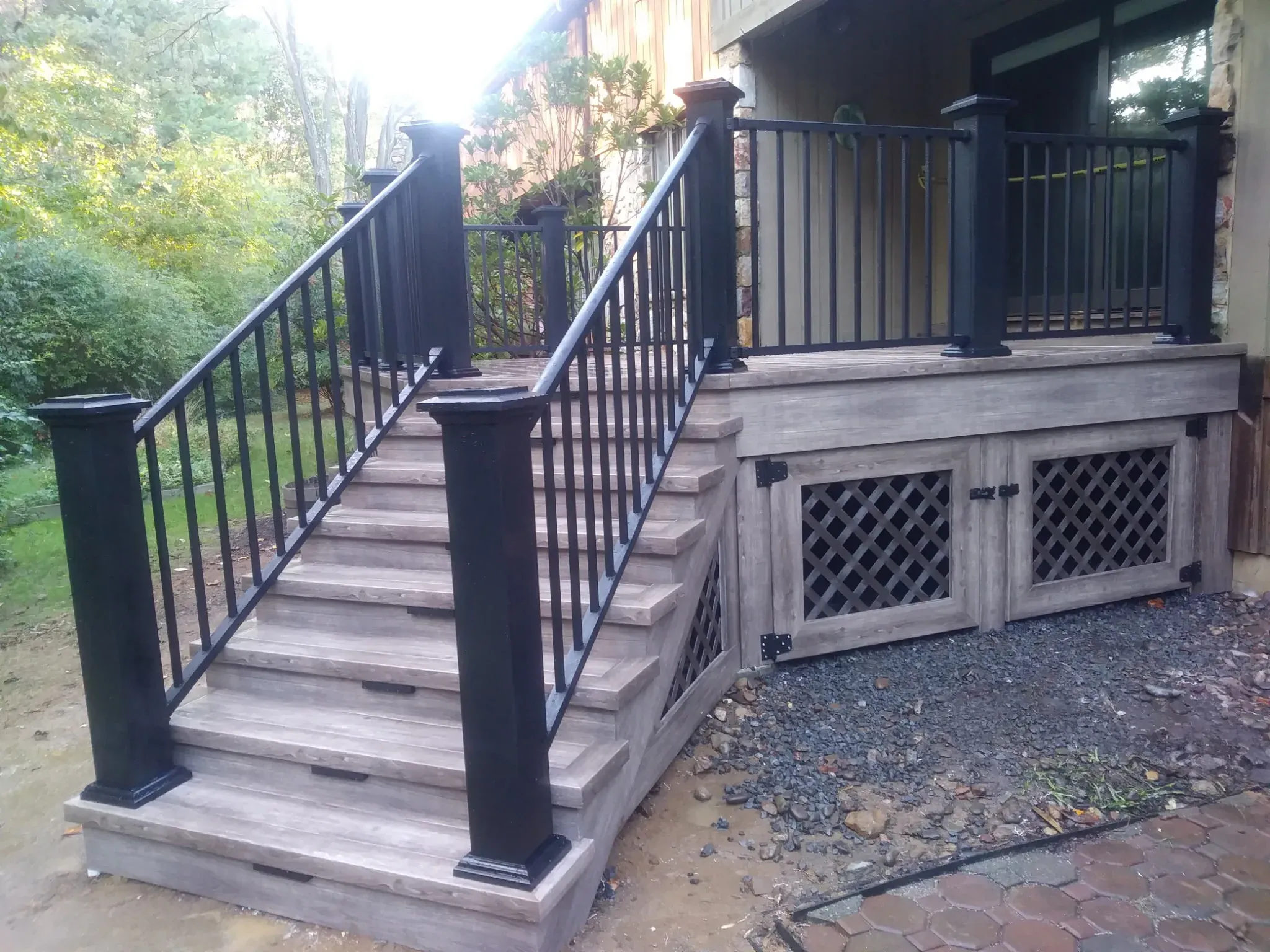 Composite deck stairs with black metal railing and decorative lattice skirt for under-deck storage, Wilmington DE