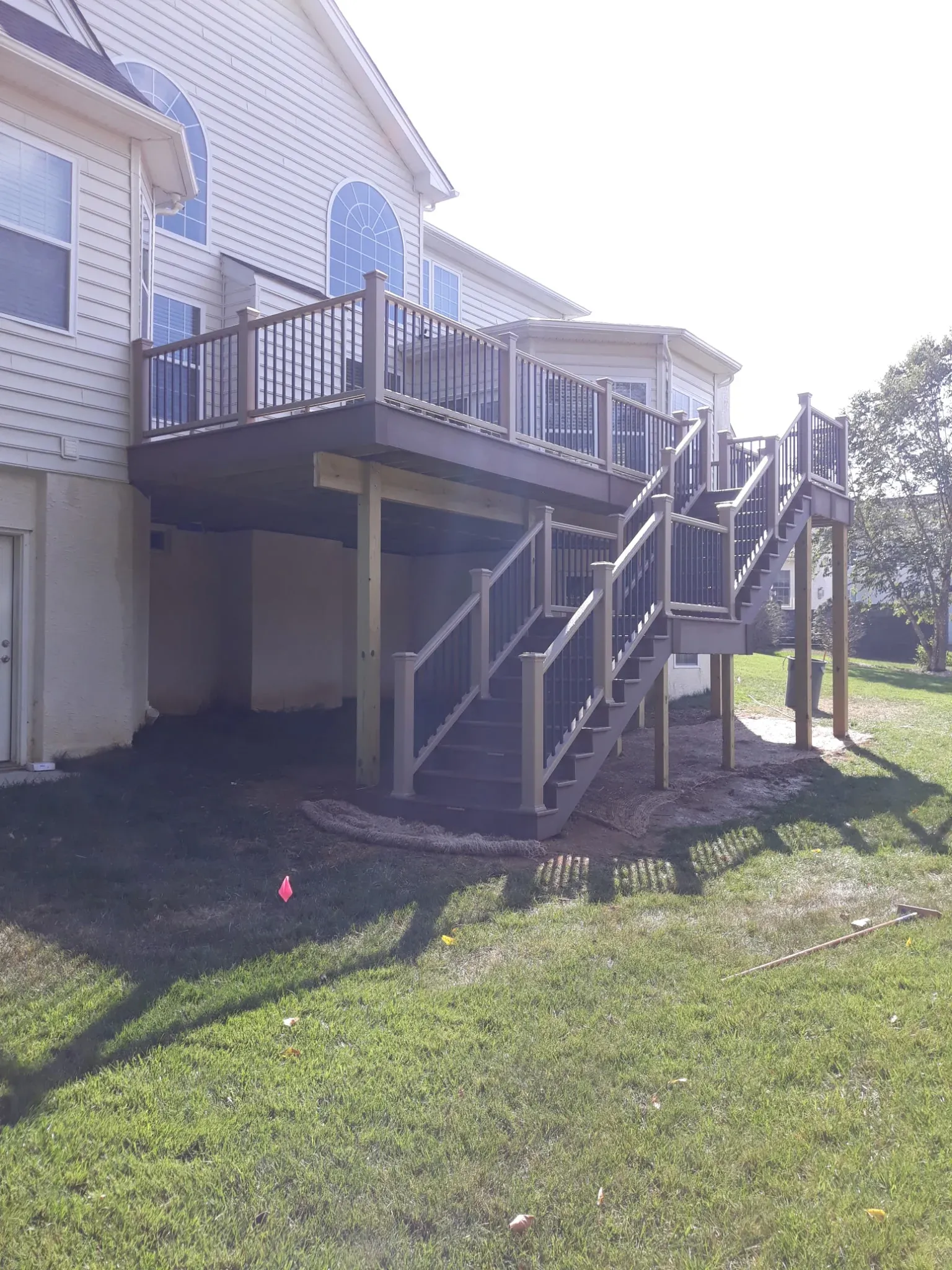 Second-story composite deck with full stair run down to the backyard, installed by Zavala & Sons