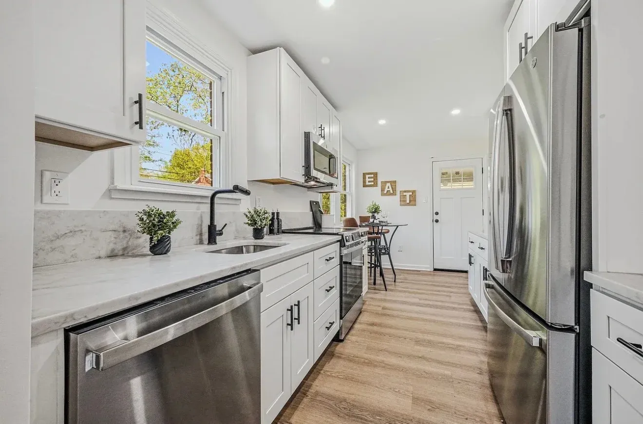 Full kitchen remodel with white shaker cabinets, marble countertops, stainless French-door refrigerator and engineered hardwood floors by Zavala & Sons in Delaware