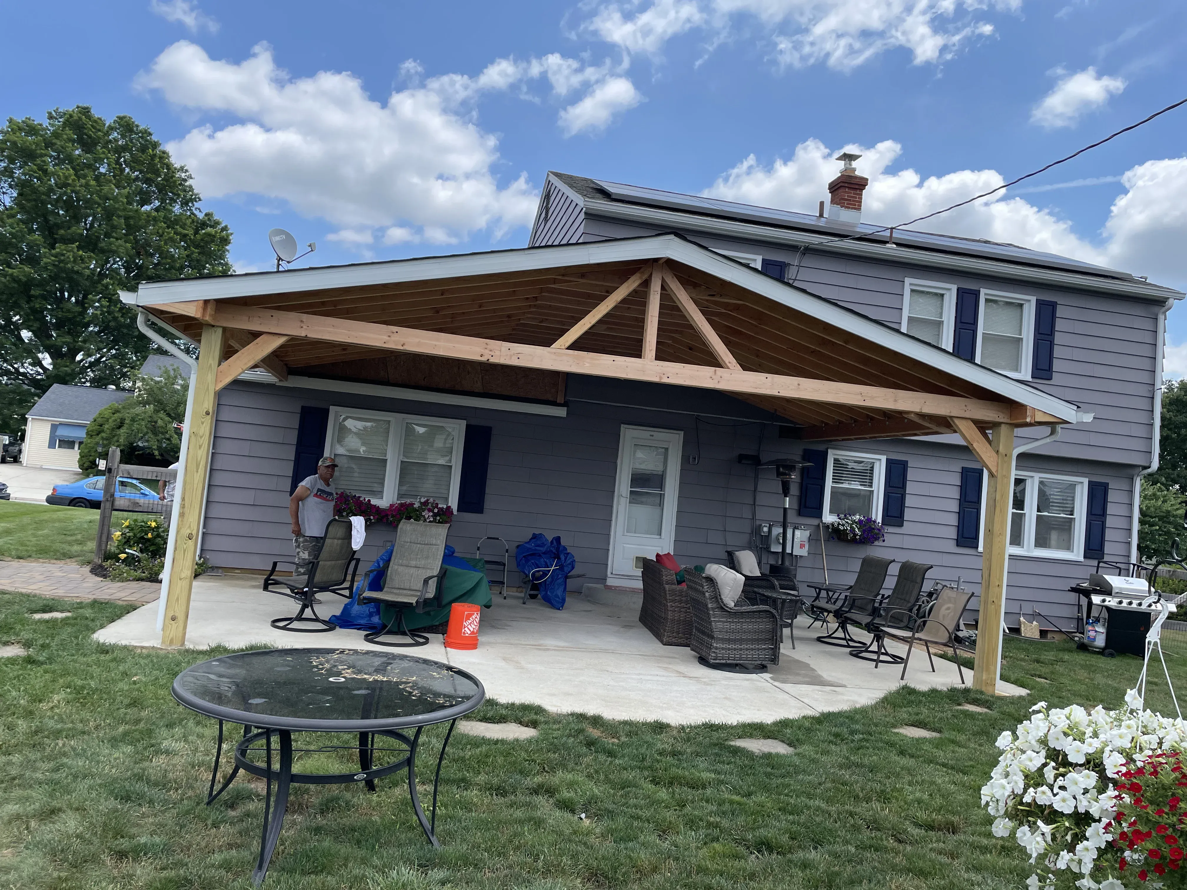 Covered porch addition with full gable roof, wood post and beam framing — exterior addition by Zavala & Sons