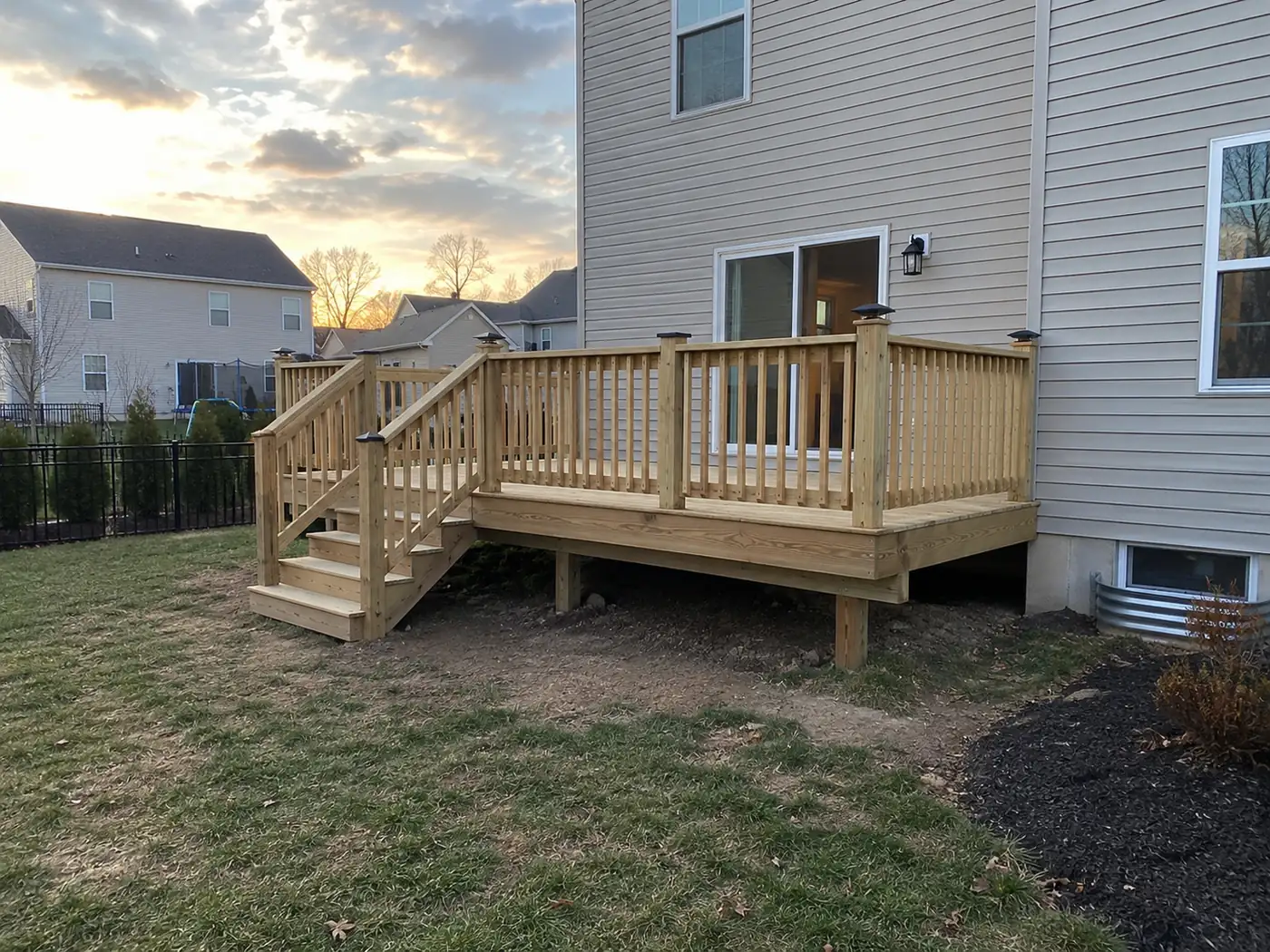 Wood deck at sunset Concept rendering: wood deck at sunset with stairs beside a siding home in Wilmington, DE